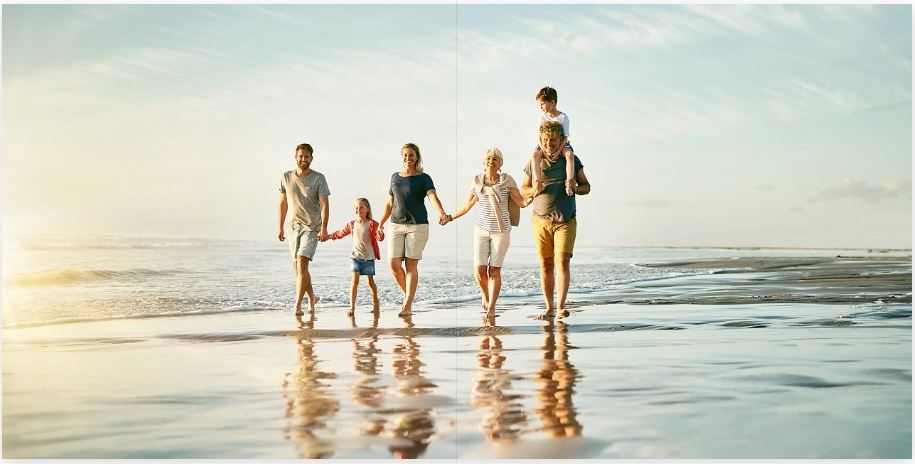 Family walking hand-in-hand on beach