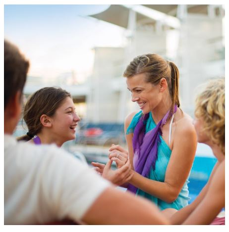 Mother and daughter smiling at each other in swimsuits